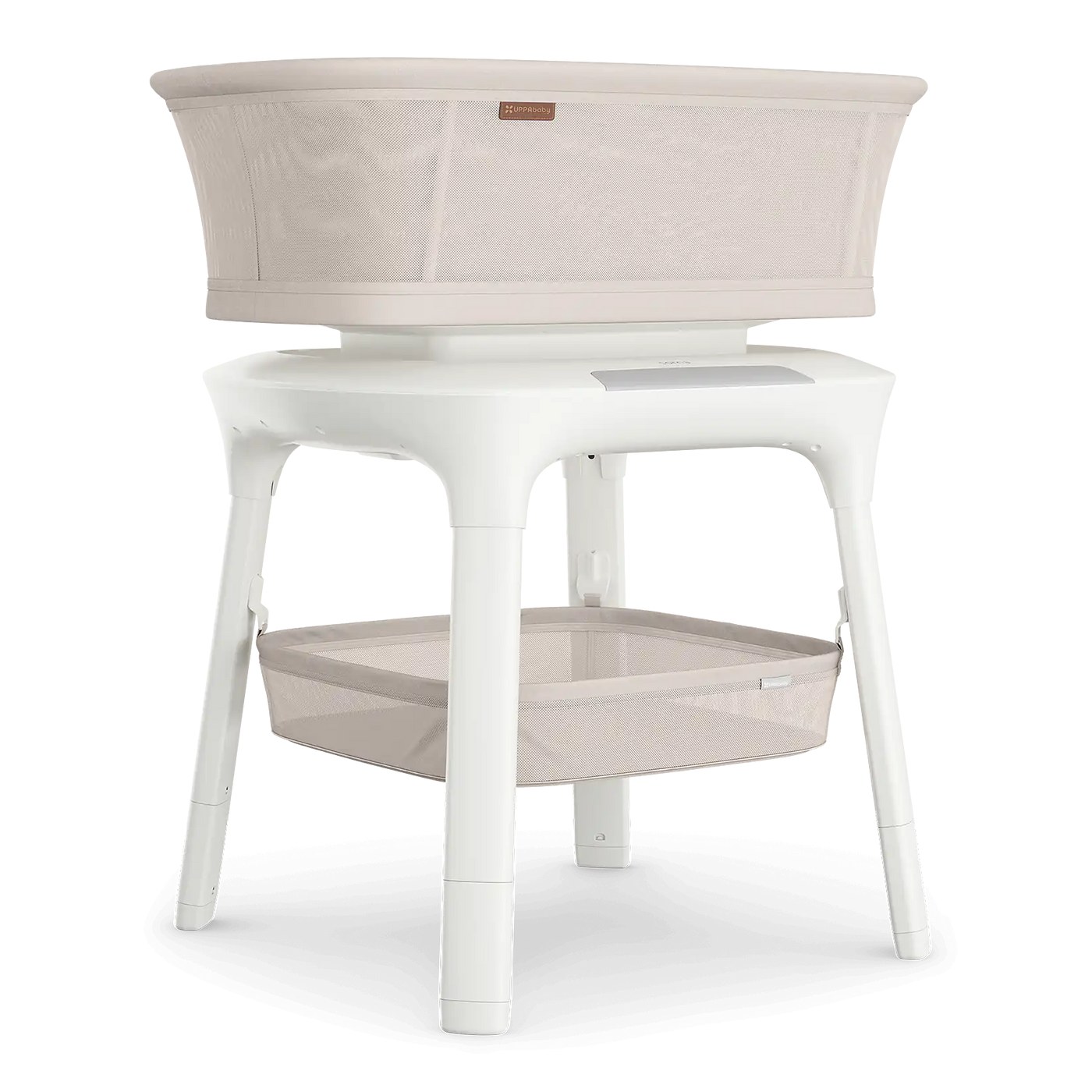 UPPAbaby Soma Smart Bassinet in cream fabric on a white pedestal base with a mesh storage basket underneath, on a white background