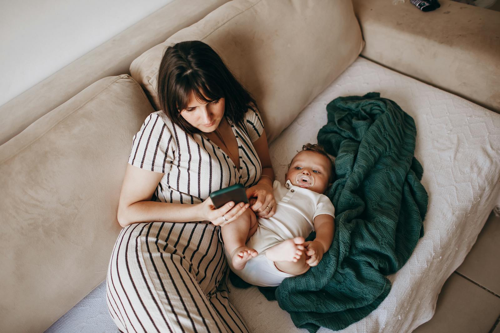 Mother and baby resting on a couch together for a feeding session