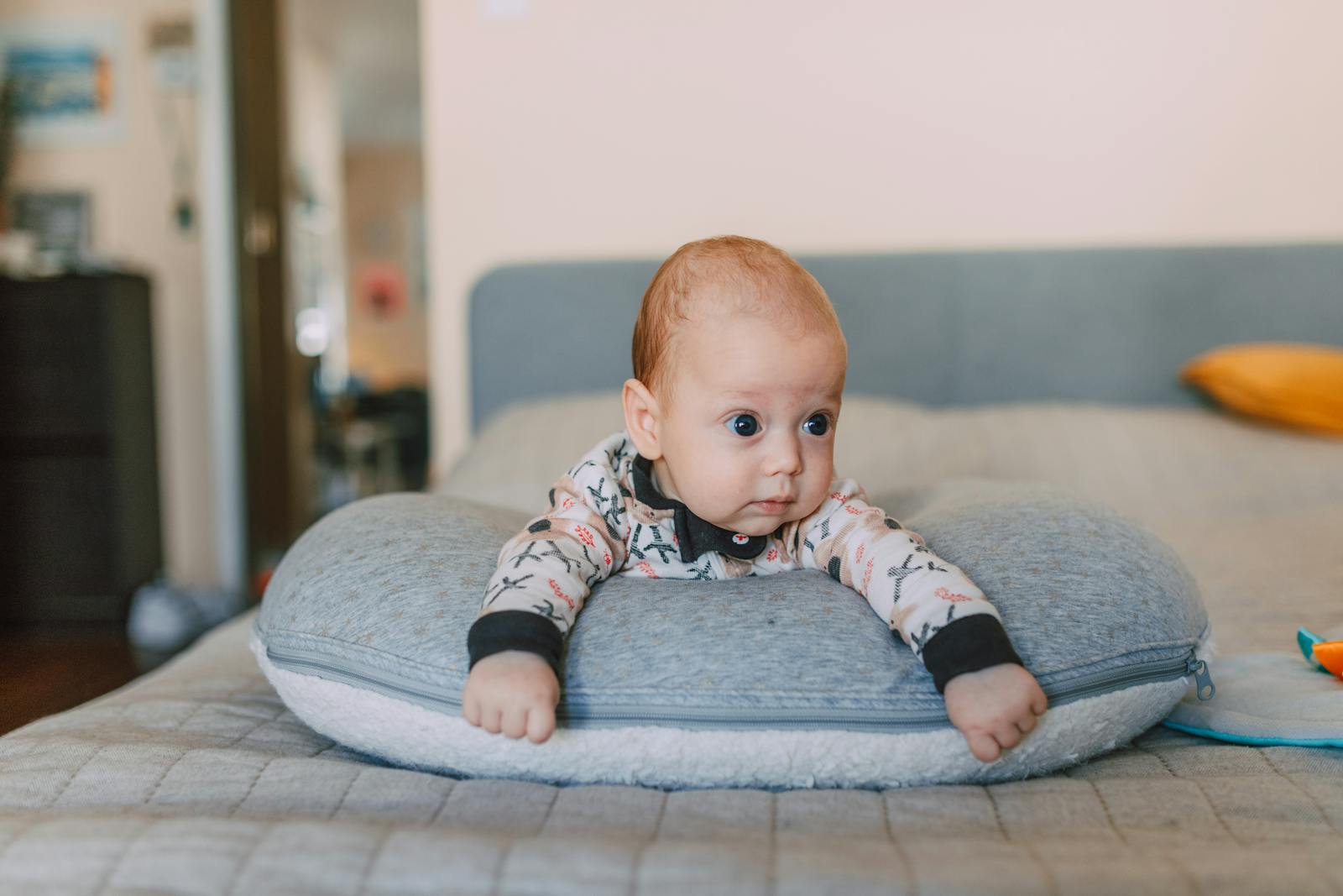 A baby resting comfortably on a nursing pillow during supervised tummy time