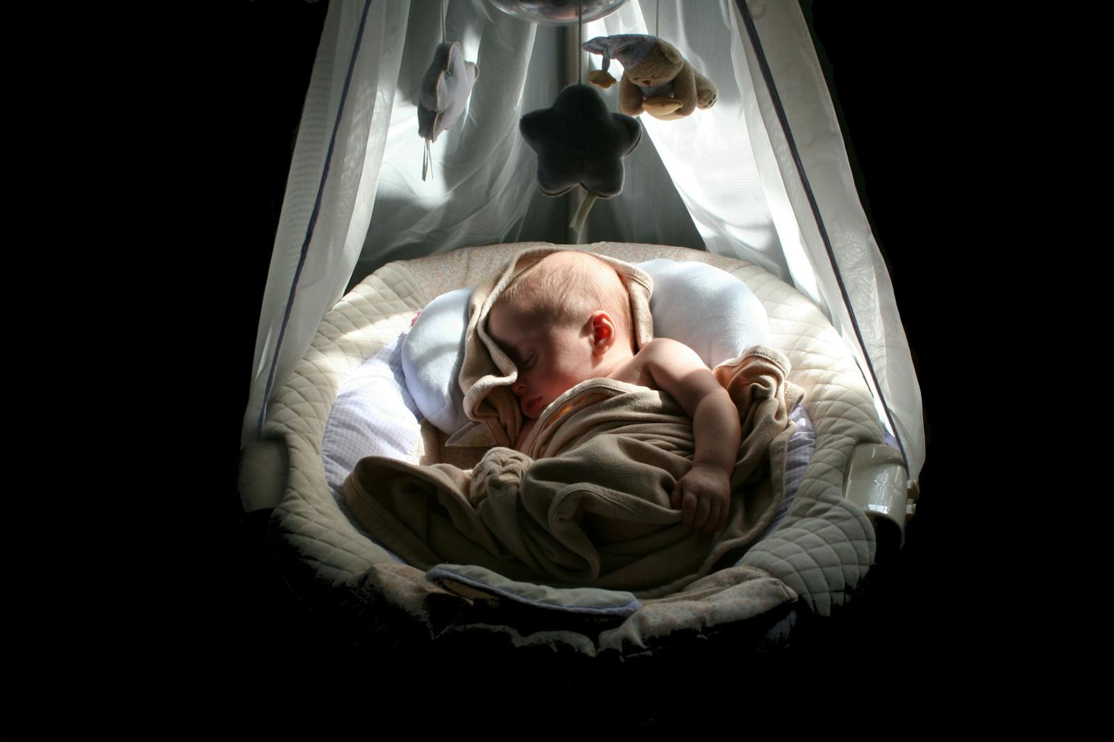 Peaceful newborn sleeping in a soft cradle, what good newborn sleep looks like
