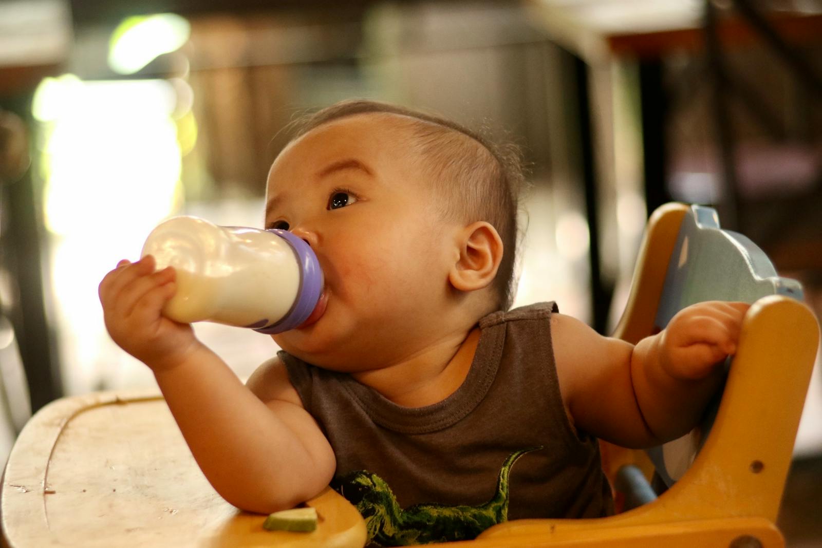 A father gently bottle feeding his baby in a calm room