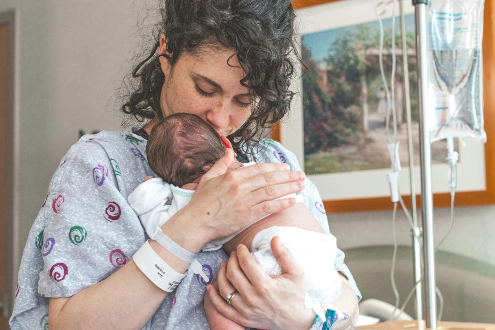 Mom holding her newborn in the hospital during the first days of breastfeeding