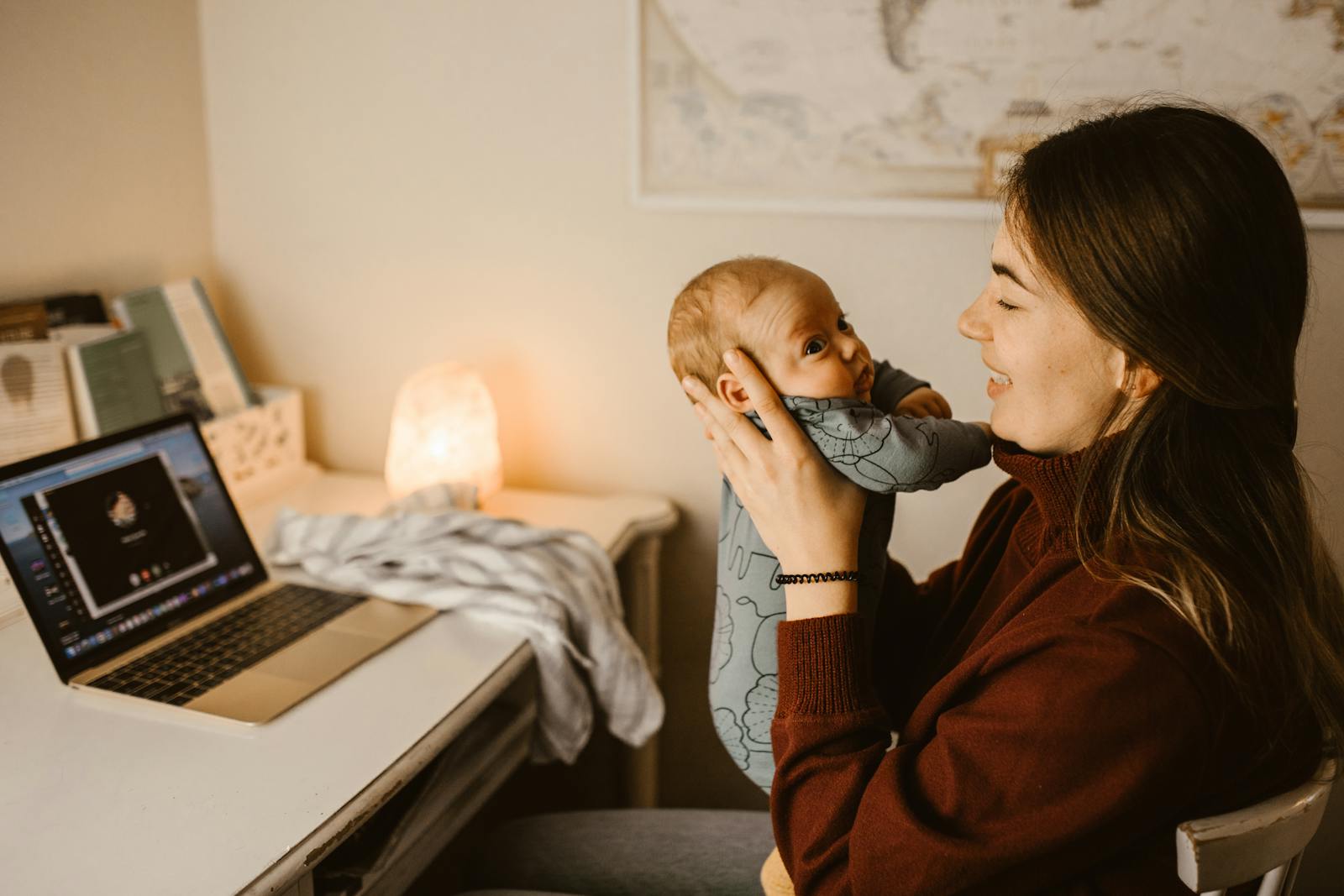 A mom gently holds her swaddled newborn after a feed