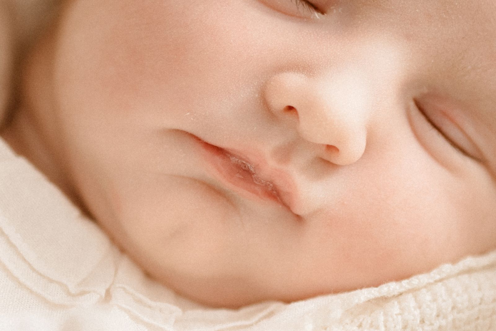 Close up of a sleeping newborn's face showing tiny nose and mouth