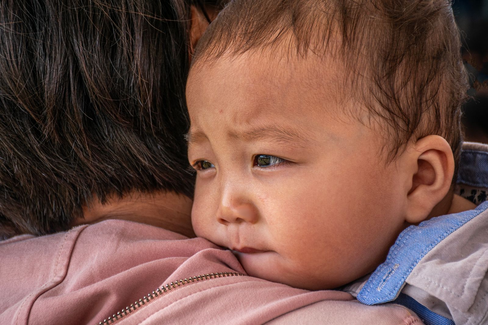 Baby resting on a caregiver's shoulder, a calm upright hold after feeding