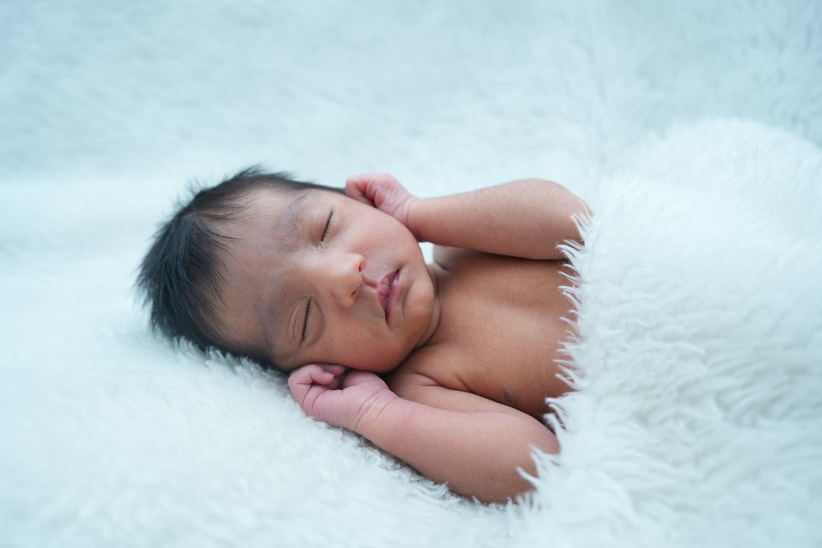 Peaceful sleeping newborn resting on a soft white blanket