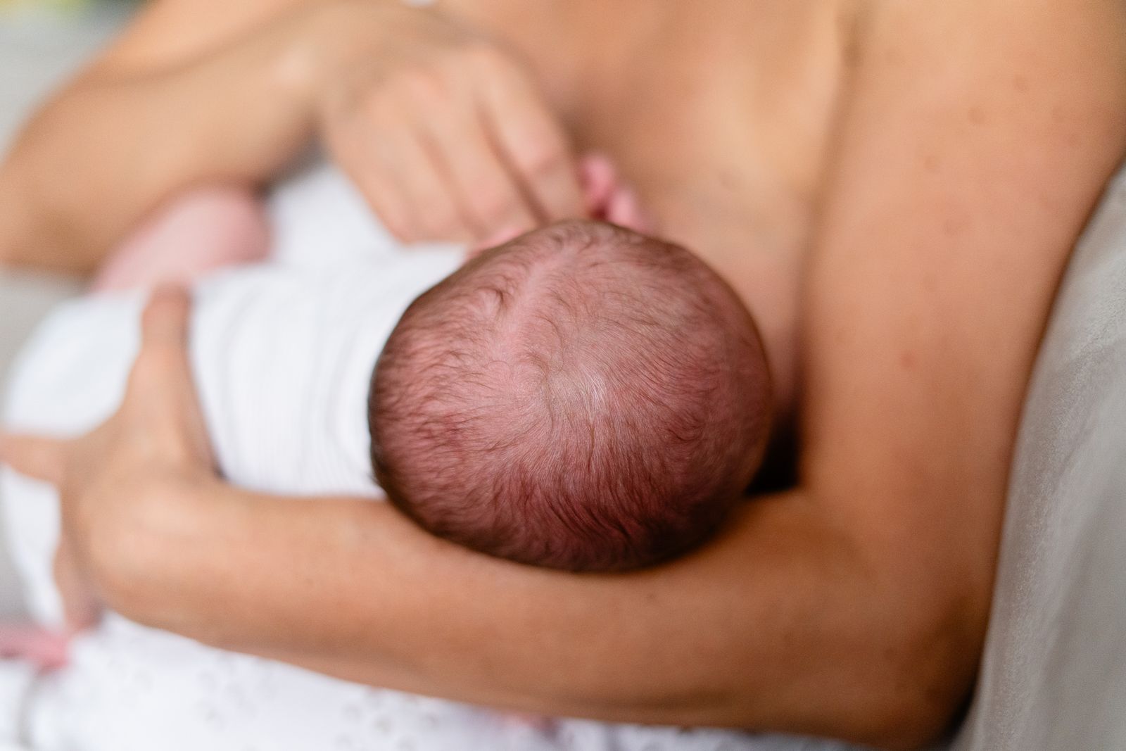 Mother holding her baby close against her chest while nursing