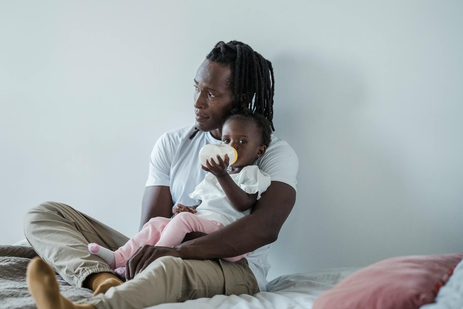 A father holding his baby upright on his lap during a paced bottle feed