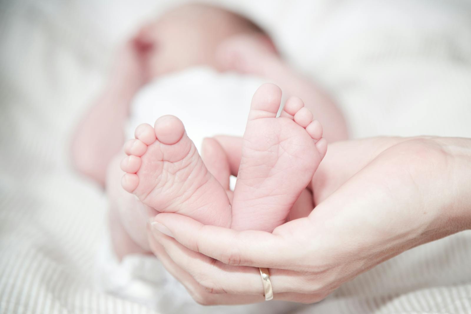 A parent's hands gently holding their newborn's tiny feet