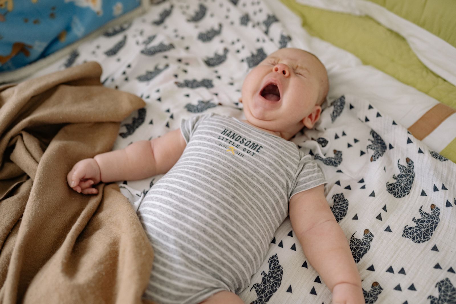 A newborn yawning wide with the mouth open and tongue visible