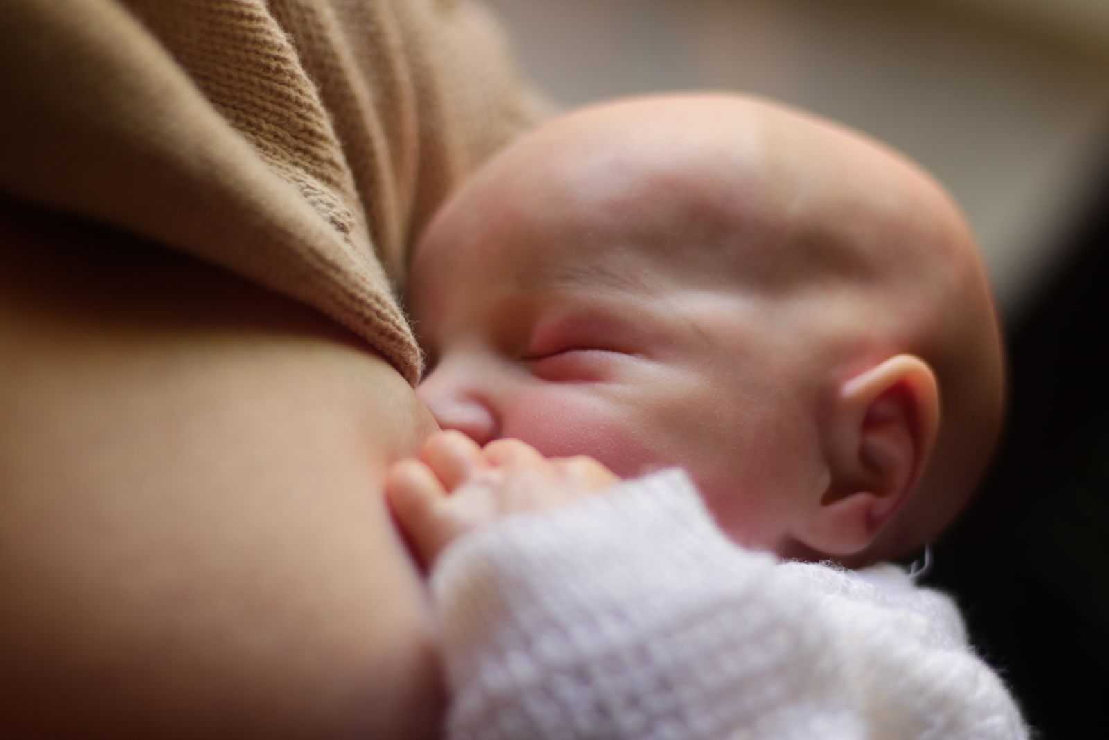 Close-up of a newborn feeding at the breast