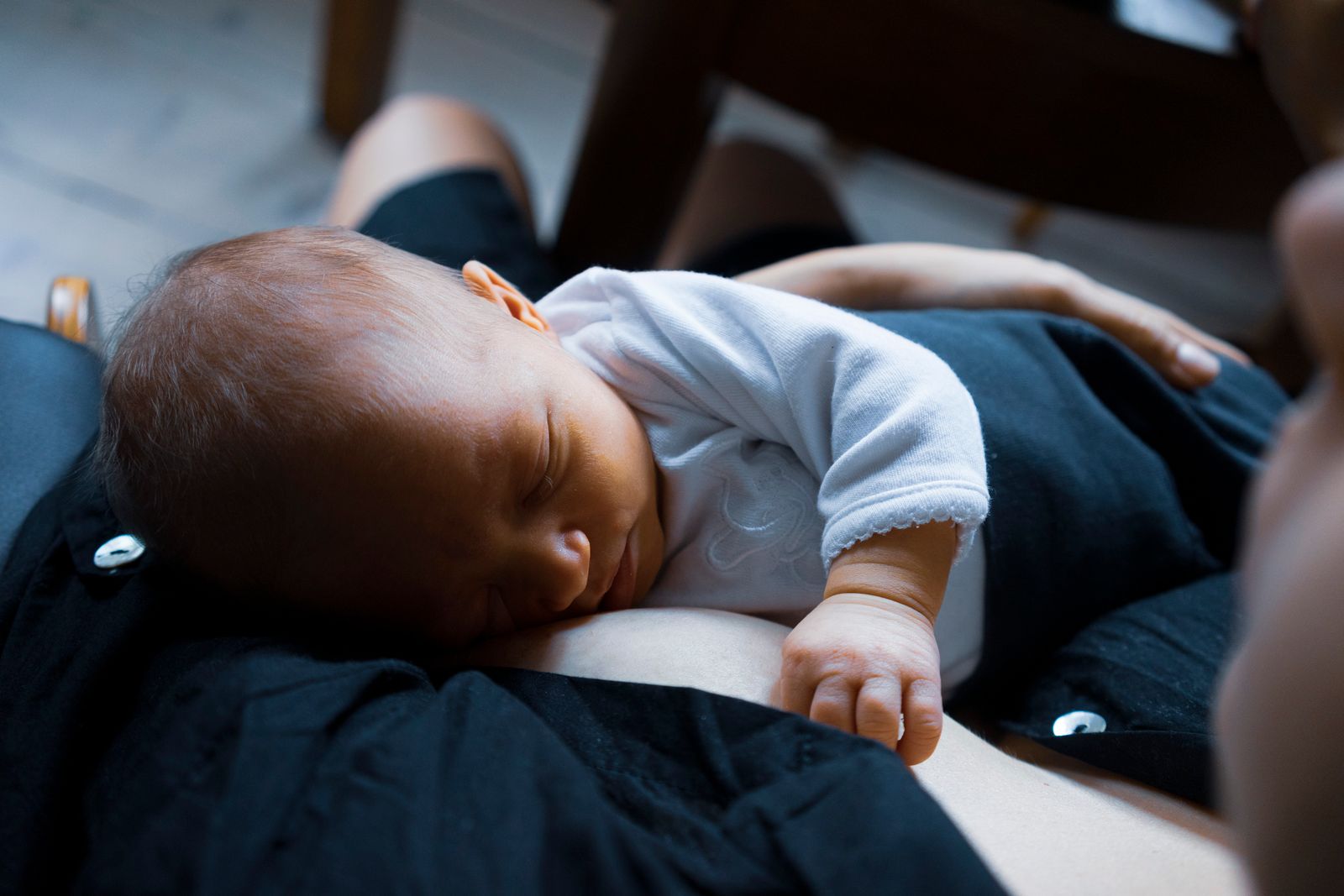 Baby lying tummy-down on a parent's chest, head turned to the side