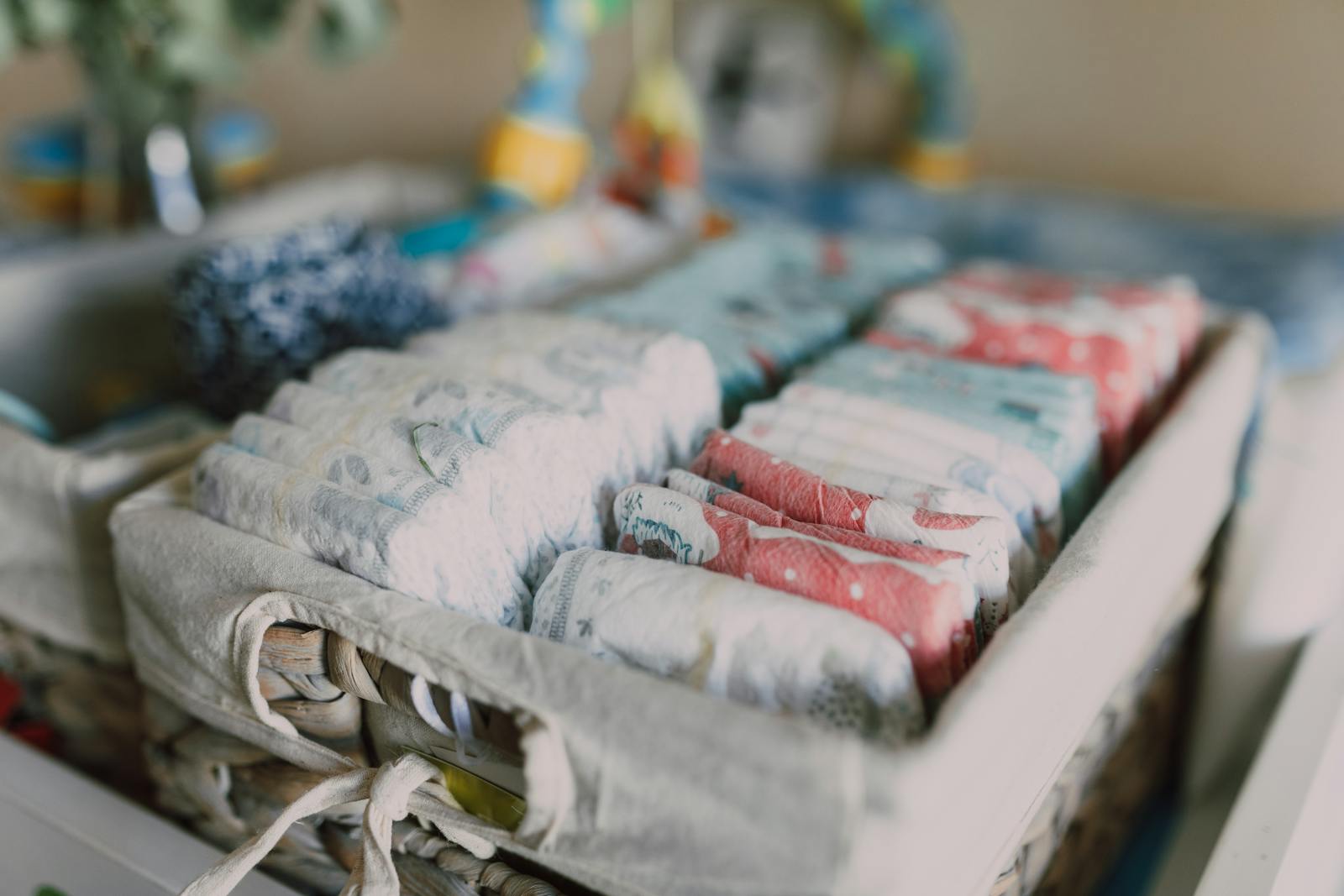 A basket of clean folded diapers waiting on a changing table