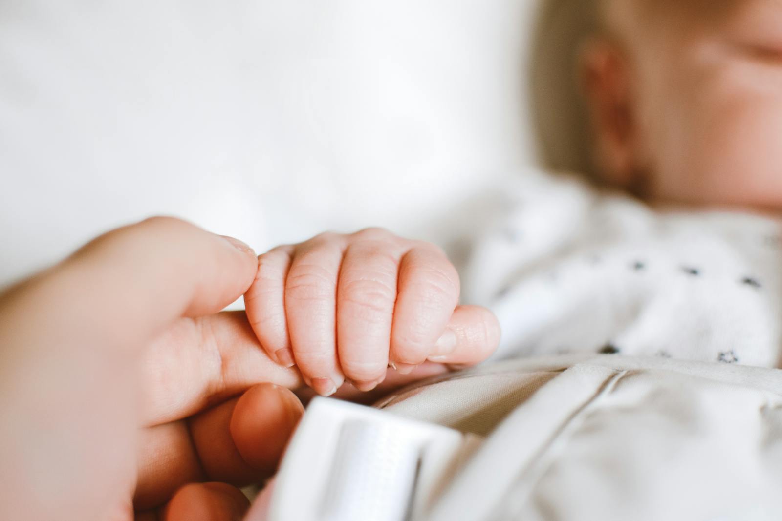 baby holding parent's finger in tender moment
